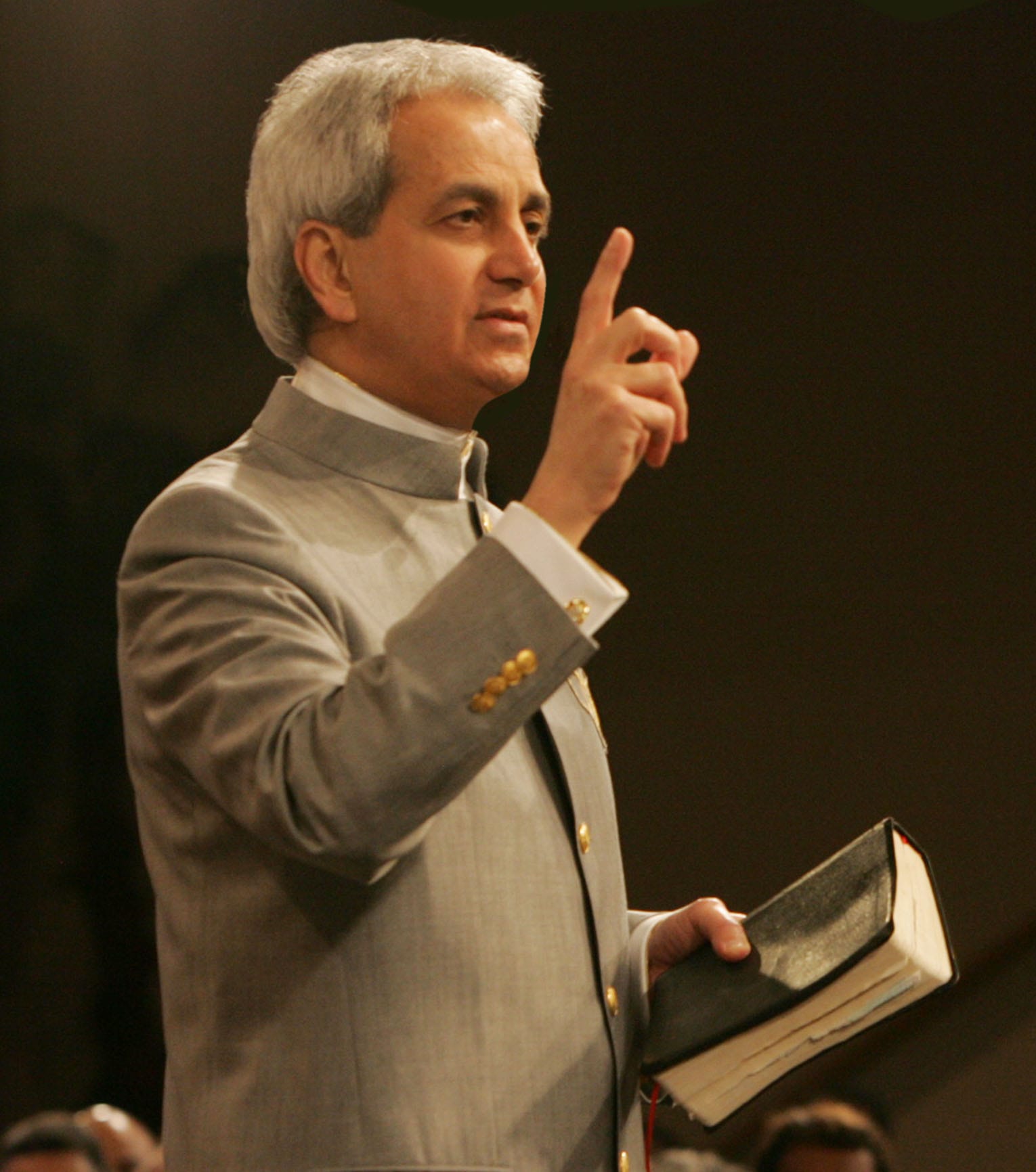 Pastor Benny Hinn holding bible - Benny Hinn Ministries Pastor Benny Hinn in a gray suit holding bible Pastor Benny Hinn holding bible - Benny Hinn Ministries Pastor Benny Hinn in a gray suit holding bible