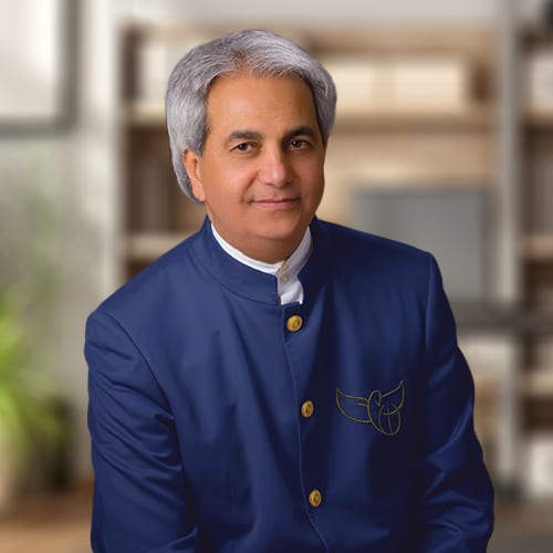 Pastor Benny Hinn sitting in an office