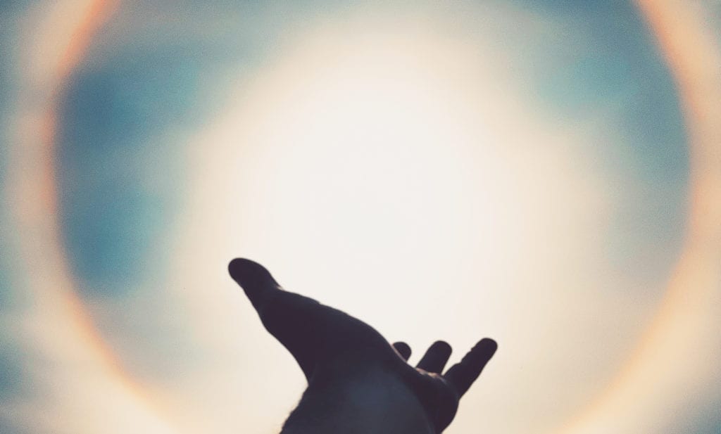 Hand reaching sun
